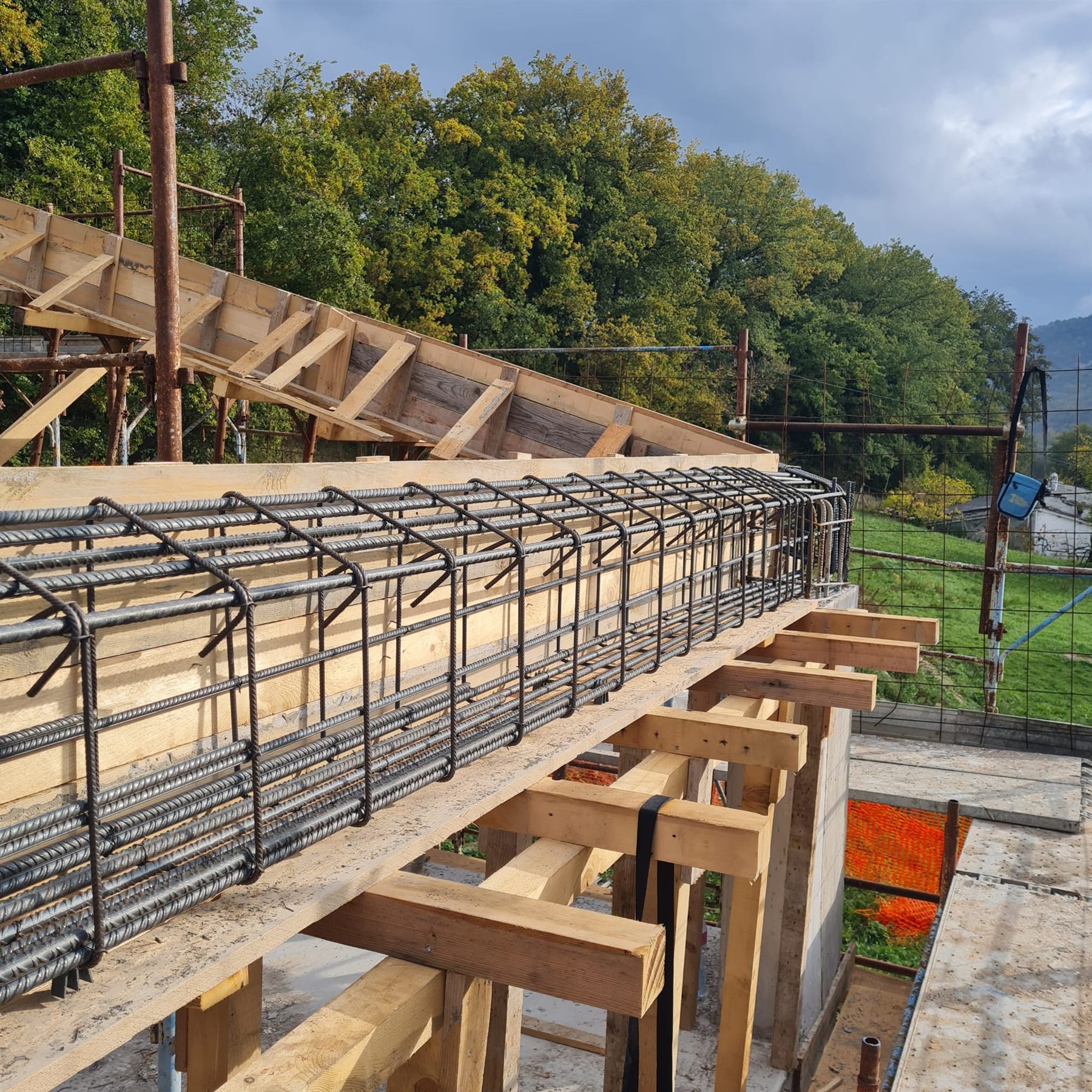Cordolo in cemento armato e copertura in legno in un cantiere di ricostruzione post-sisma
